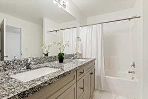 Bathroom with shower / bathtub combination with curtain and vanity