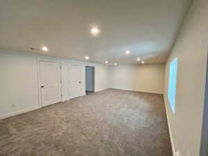 Below grade area with recessed lighting, carpet flooring, visible vents, and baseboards