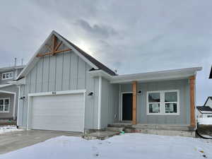 View of front of home with a garage and central air condition unit