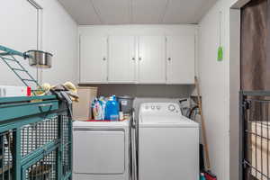 Laundry area featuring cabinets and separate washer and dryer