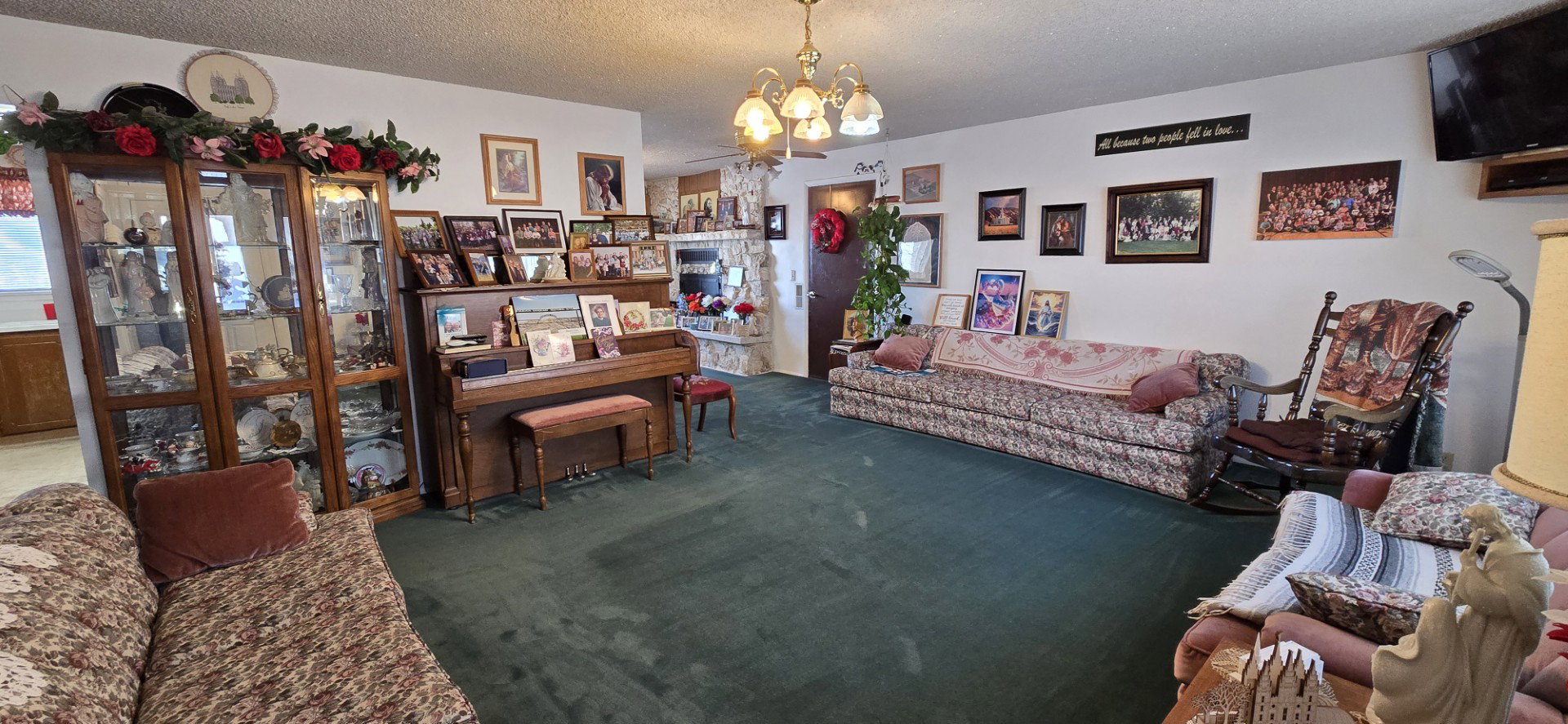 Living room with carpet floors, a chandelier, and a textured ceiling