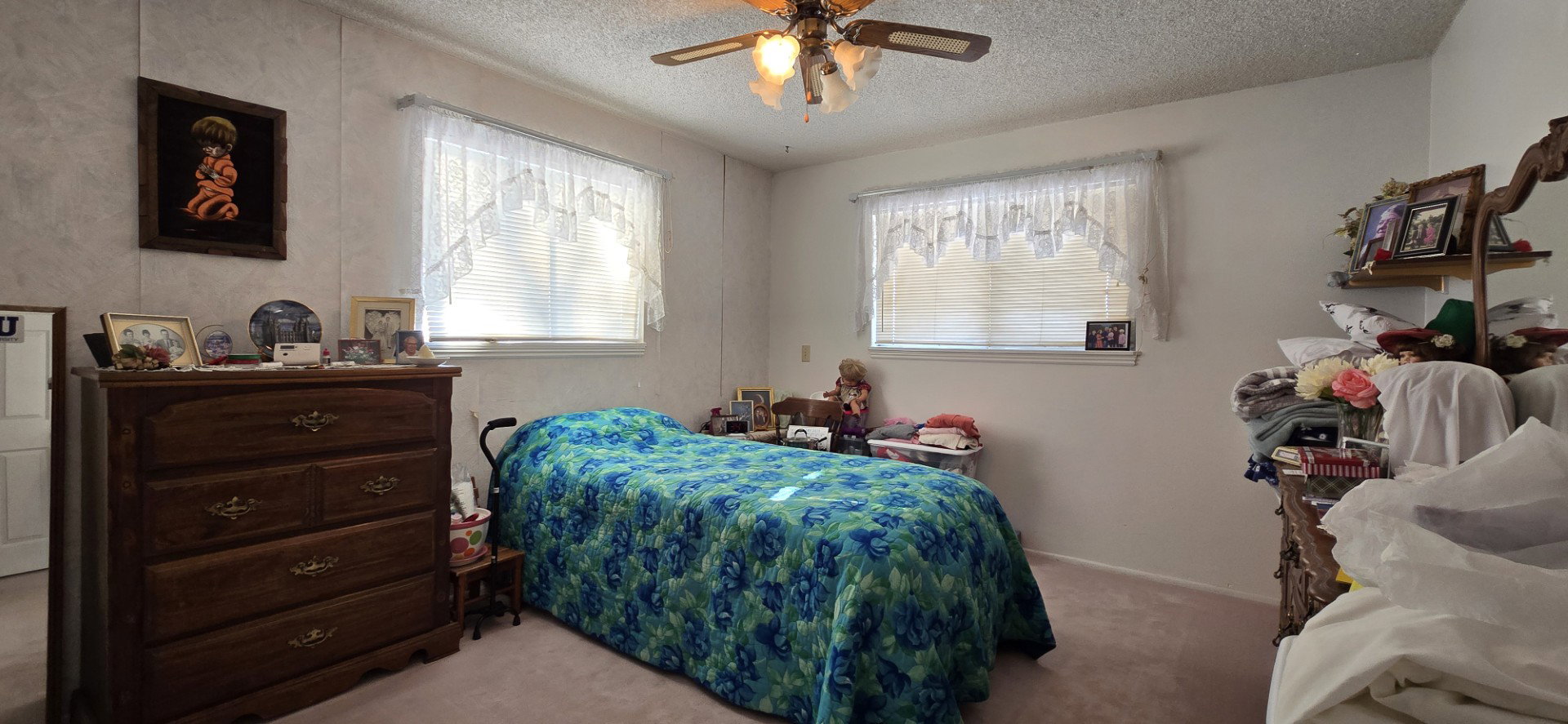 Carpeted bedroom with a textured ceiling and ceiling fan