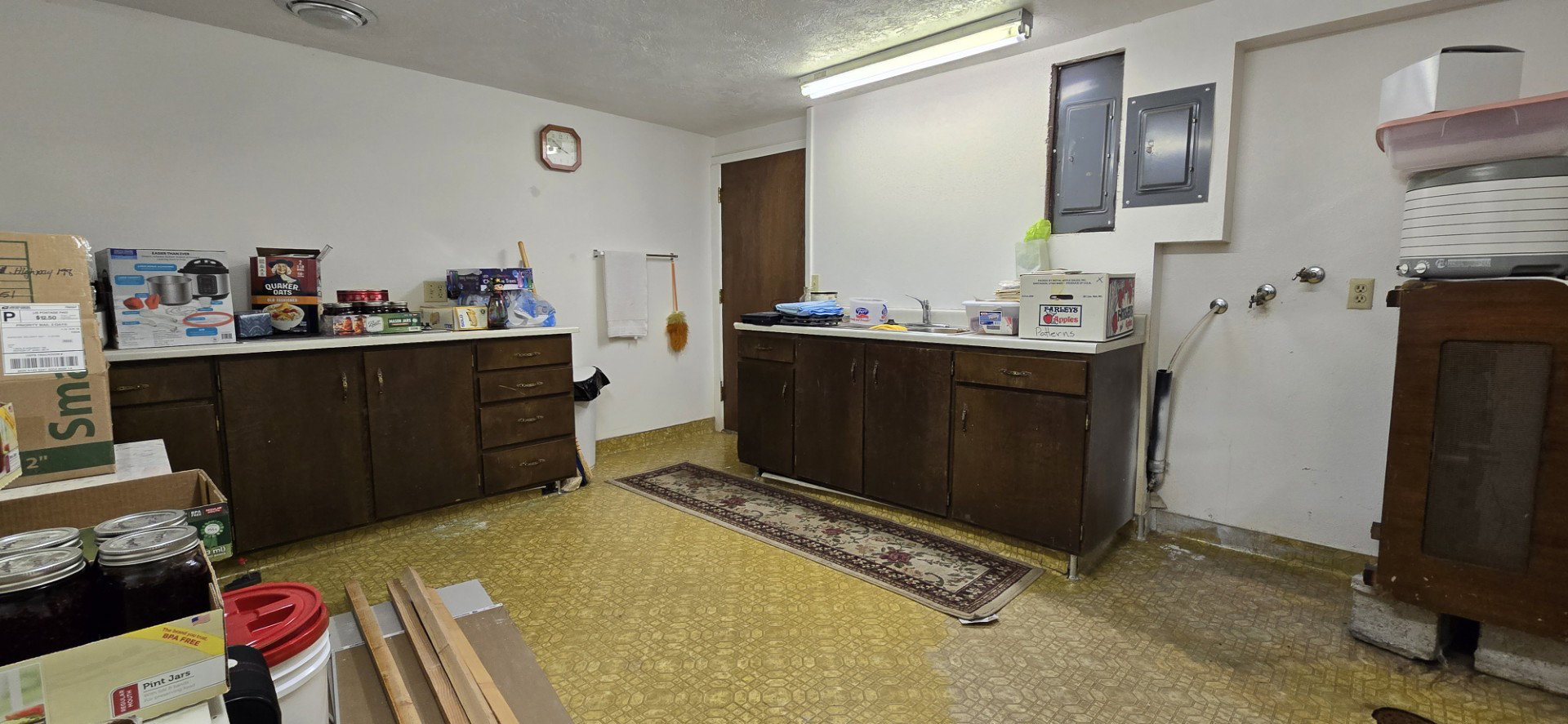 Kitchen featuring electric panel, dark brown cabinets, and a textured ceiling