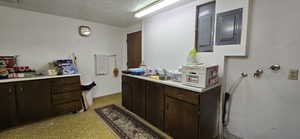 Bathroom featuring sink, electric panel, and a textured ceiling