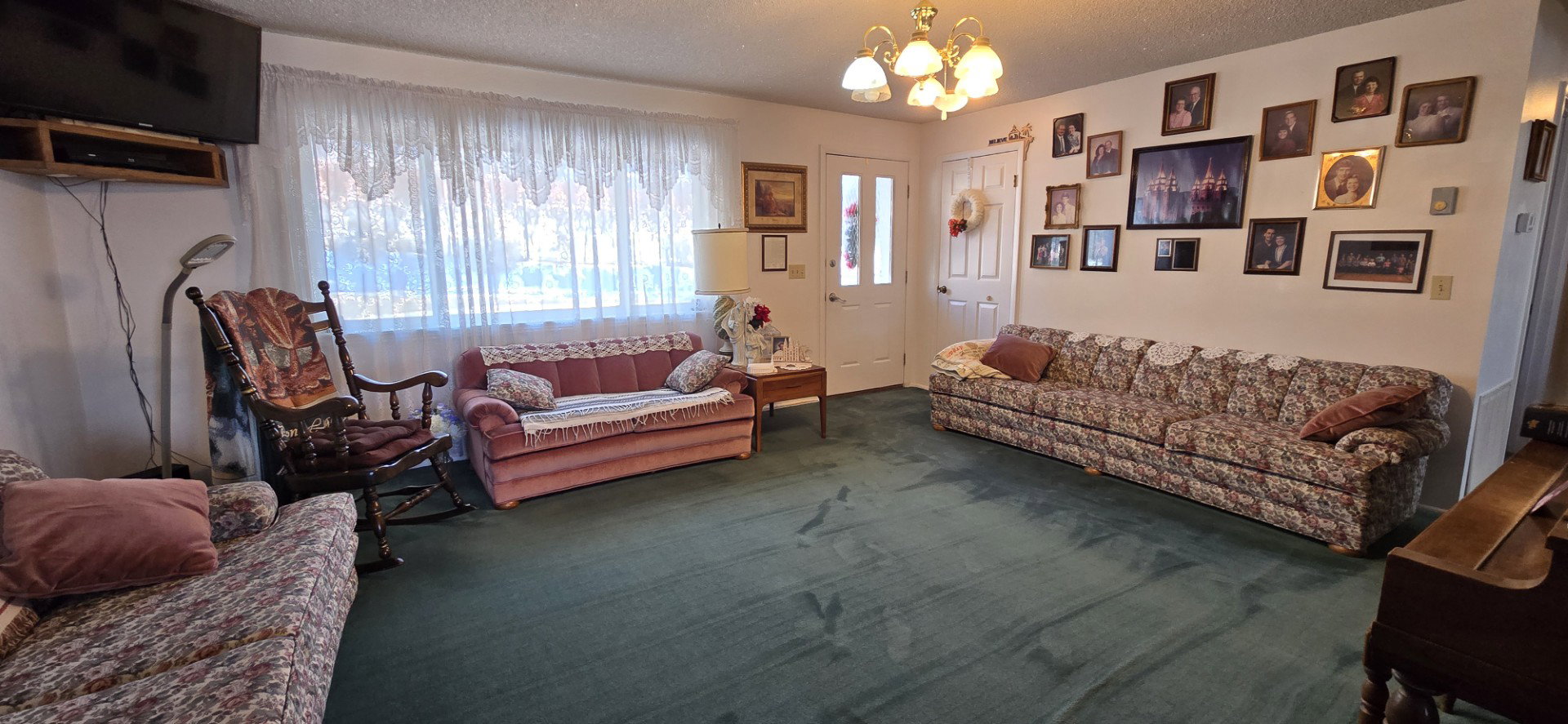 Living room with carpet floors, an inviting chandelier, and a textured ceiling