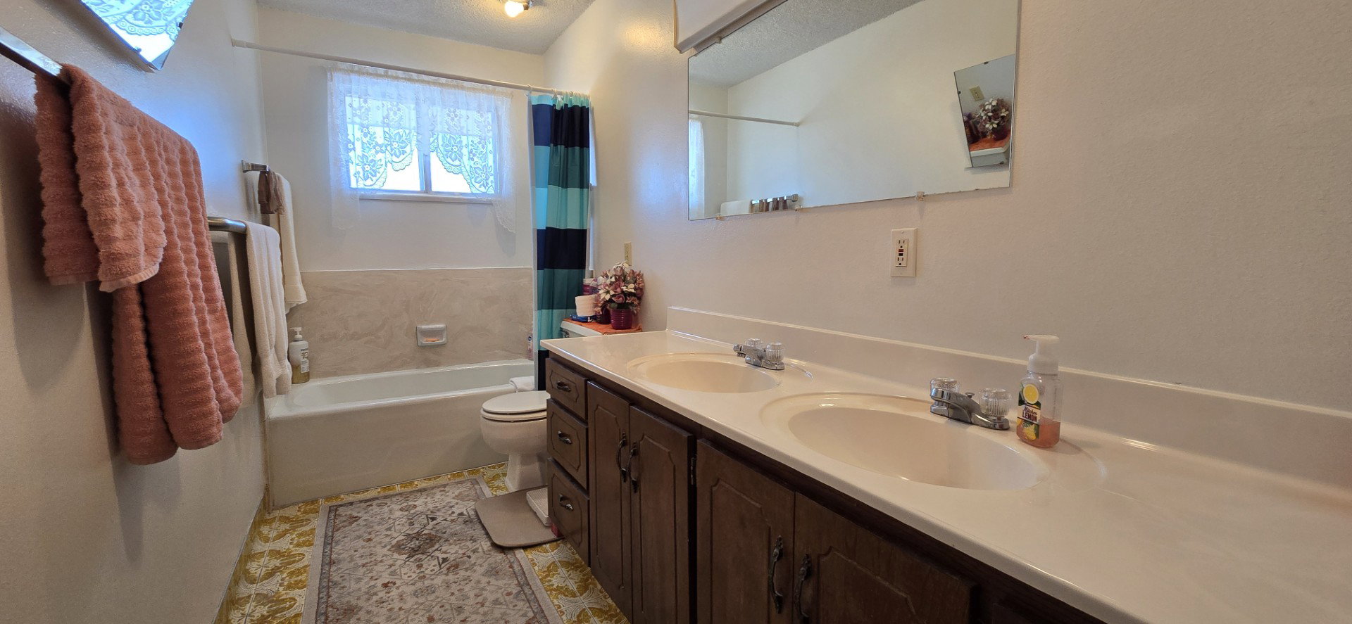 Full bathroom with vanity, shower / tub combo with curtain, and toilet