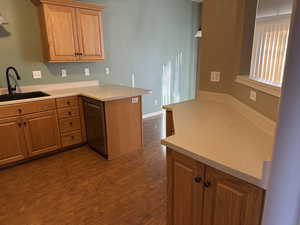 Kitchen with dark hardwood / wood-style floors, kitchen peninsula, and sink