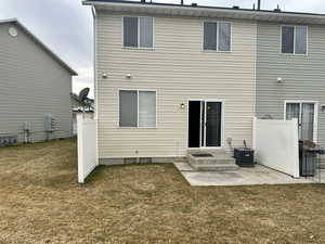 Back of property with a yard, a patio, and central air condition unit