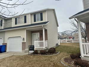 View of the stylish front of house with a mountain view, a garage, and a front lawn