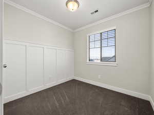 Carpeted empty room with crown molding