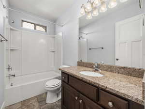 Full bathroom with vanity, washtub / shower combination, and toilet