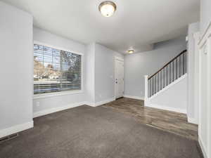 Foyer entrance with dark colored carpet