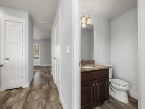 Bathroom with vanity, toilet, and hardwood / wood-style floors