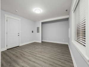 Spare room with dark wood-type flooring, electric panel, and a textured ceiling