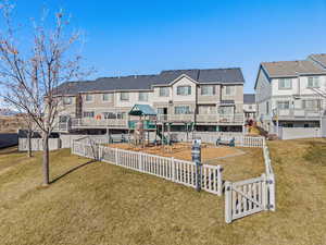 Rear view of house featuring a yard and a playground