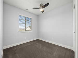 Carpeted empty room with ceiling fan