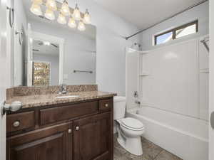 Full bathroom with vanity, shower / tub combination, tile patterned floors, and toilet