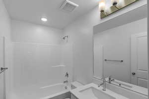 Full bathroom featuring bathtub / shower combination, vanity, and toilet