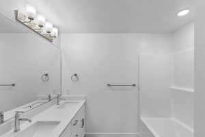 Primary bathroom offers double vanity sinks and a separate toilet closet