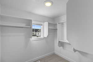 Primary walk-in closet has natural lighting from the added window