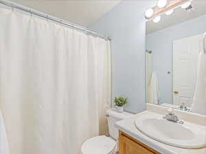 Bathroom with vanity, toilet, and a textured ceiling