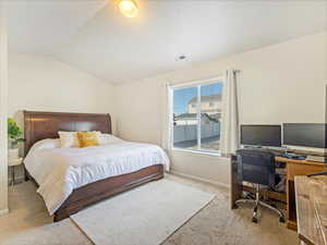 Carpeted bedroom with lofted ceiling