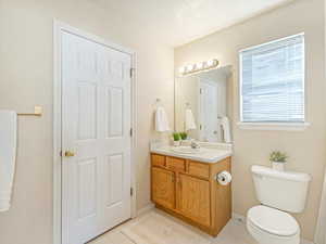 Bathroom with tile patterned floors, toilet, vanity, and a textured ceiling