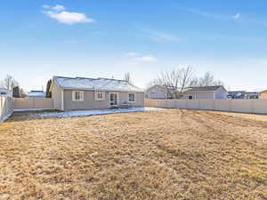 Back of property featuring a patio area and a lawn