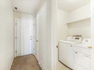 Laundry area with washing machine and dryer and light carpet