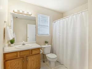 Bathroom with vanity, toilet, and tile patterned flooring