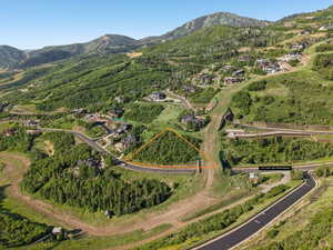 Aerial overview of property's location with property boundaries highlighted and a mountain backdrop