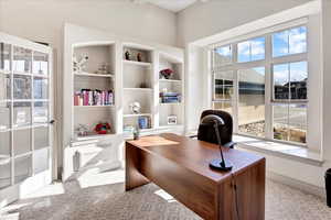 Office area featuring built in shelves.