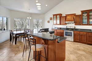 Kitchen featuring appliances with stainless steel finishes, decorative light fixtures, a kitchen island with sink, and a wealth of natural light