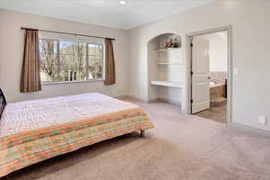 Bedroom featuring light carpet and ensuite bath