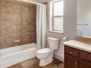 Full bathroom featuring vanity, toilet, and shower / tub combo