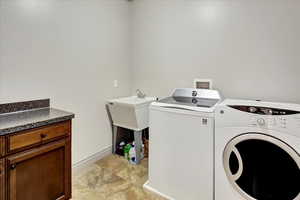 Laundry area with cabinets and washing machine and clothes dryer