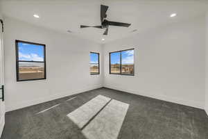 Carpeted spare room featuring ceiling fan