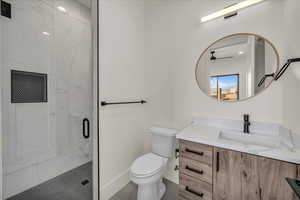 Bathroom with vanity, a shower with shower door, and toilet