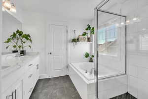 Bathroom featuring vanity and shower with separate bathtub