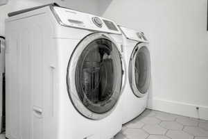 Laundry area featuring light tile patterned floors and washer and dryer