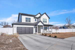 View of front of property with a garage, covered porch, and solar panels