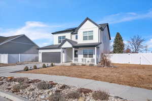 View of front of house with a garage, covered porch, and solar panels