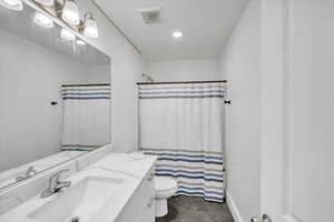 Bathroom featuring vanity, toilet, and a shower with shower curtain