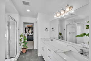 Bathroom featuring vanity and walk in shower and bathtub