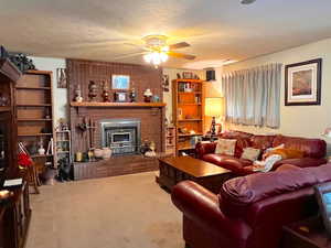 Carpeted living room with a textured ceiling and ceiling fan