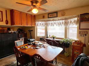 Dining room featuring ceiling fan and a textured ceiling