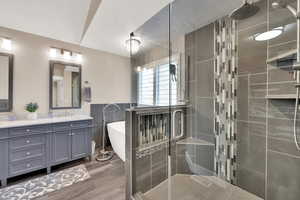 Bathroom featuring vanity, shower with separate bathtub, and hardwood / wood-style floors