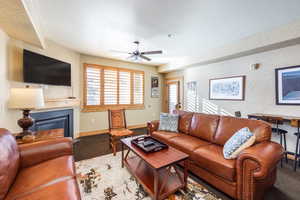 Living room with a textured ceiling, carpet floors, and ceiling fan