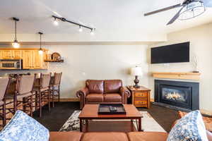 Carpeted living room featuring ceiling fan