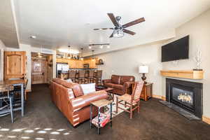 Carpeted living room featuring ceiling fan